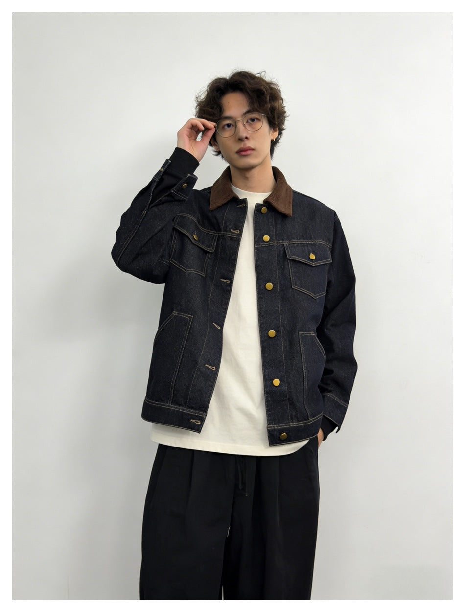 Model wearing the front of a dark indigo denim jacket with a brown collar, contrast stitching and brass-tone buttons.