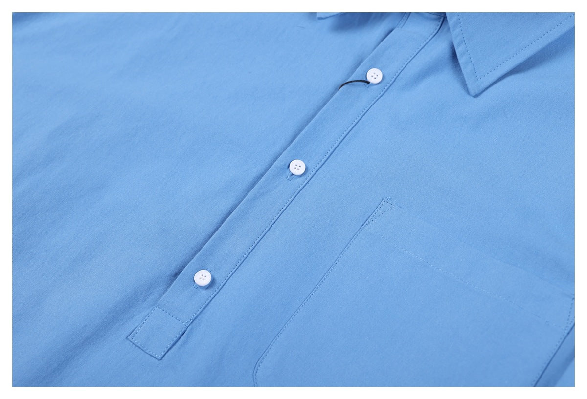 Close-up of the light blue shirt front with a button placket and chest pocket.