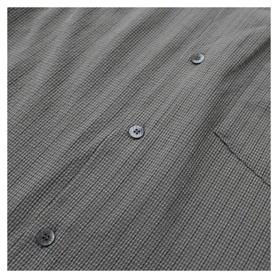 Close-up of the gray micro-check shirt's button front and edge of a chest pocket.
