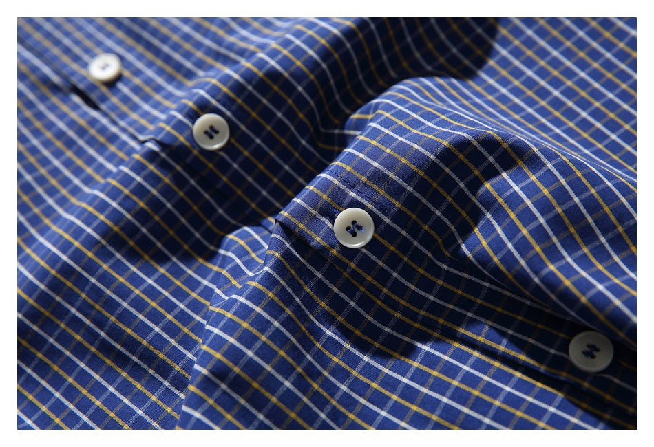 Close-up of white buttons on the blue plaid shirt fabric.