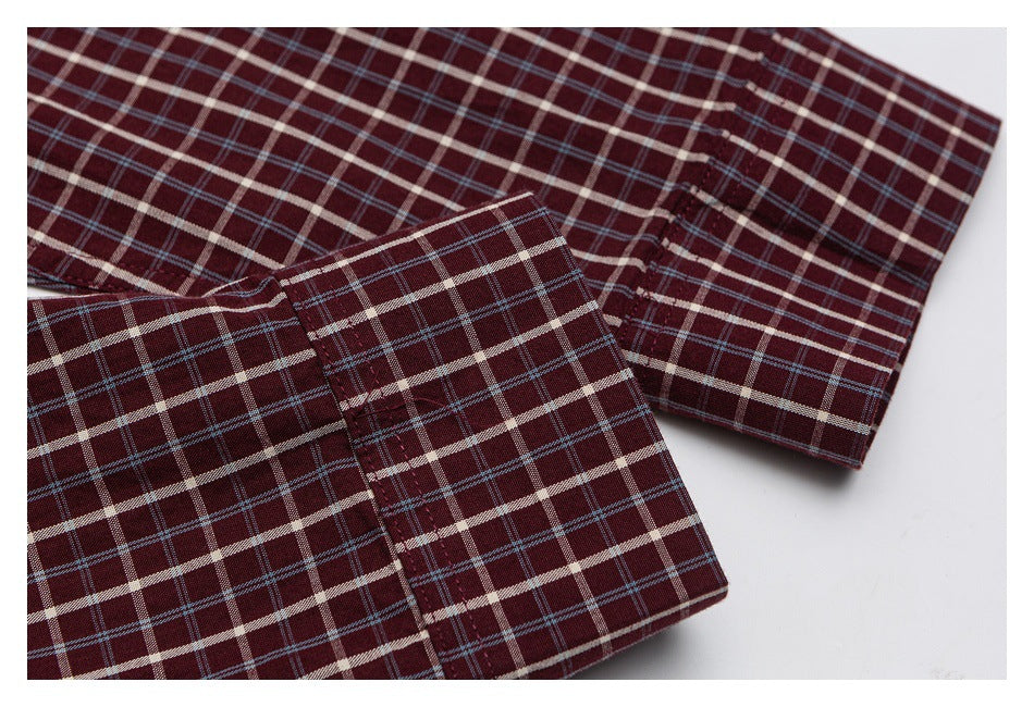 Close-up of a folded cuff and sleeve on a burgundy shirt with cream and blue plaid.
