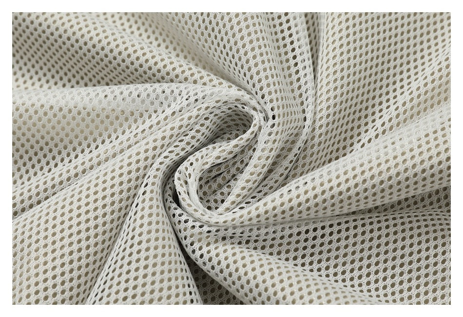 Close-up of off-white open mesh fabric gathered into folds.