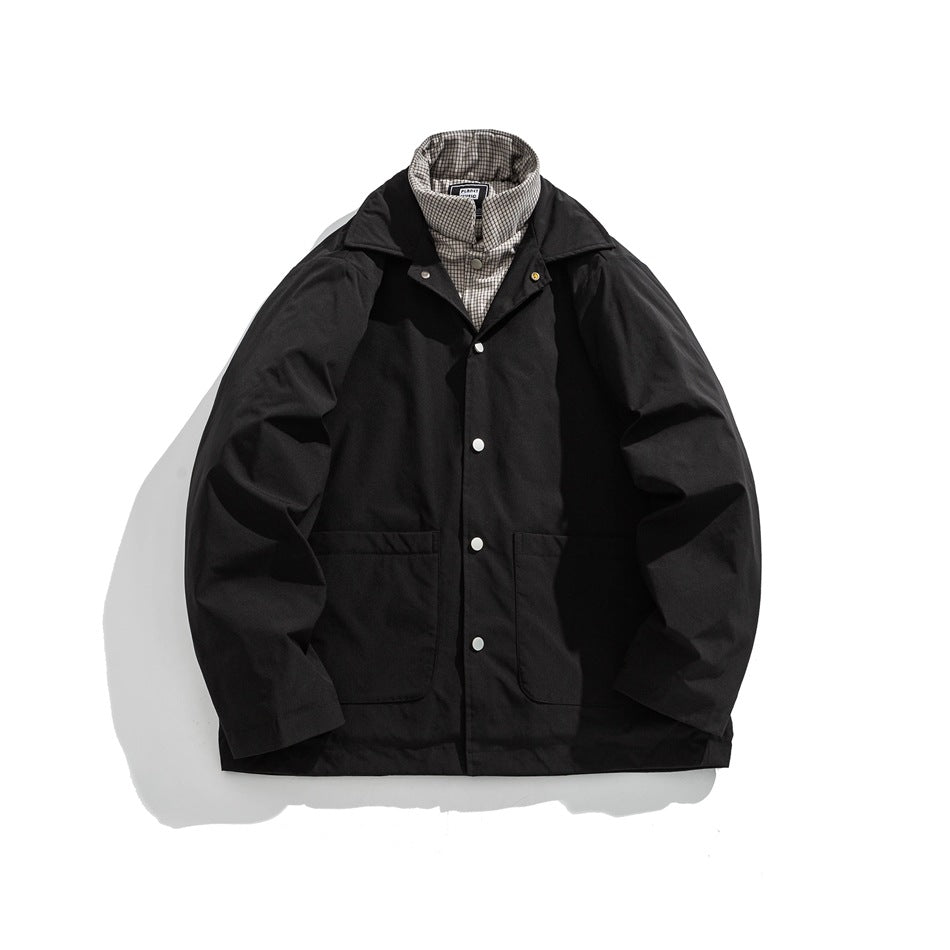 Black button-front jacket with wide collar, two patch pockets and plaid inner collar layer, flat lay