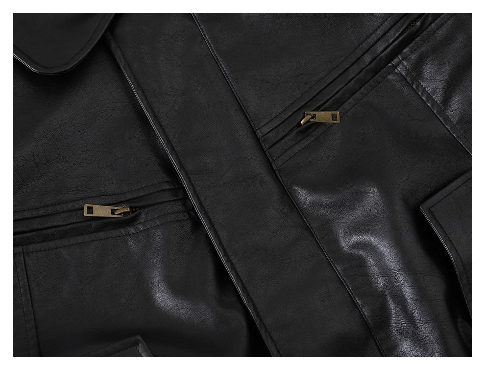 Close-up of a black jacket with a wide lapel and two diagonal zip pockets with brass-colored pulls.