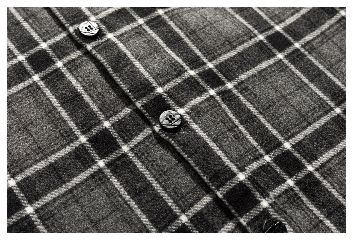 Close-up of the charcoal gray plaid shirt's button placket and black buttons.