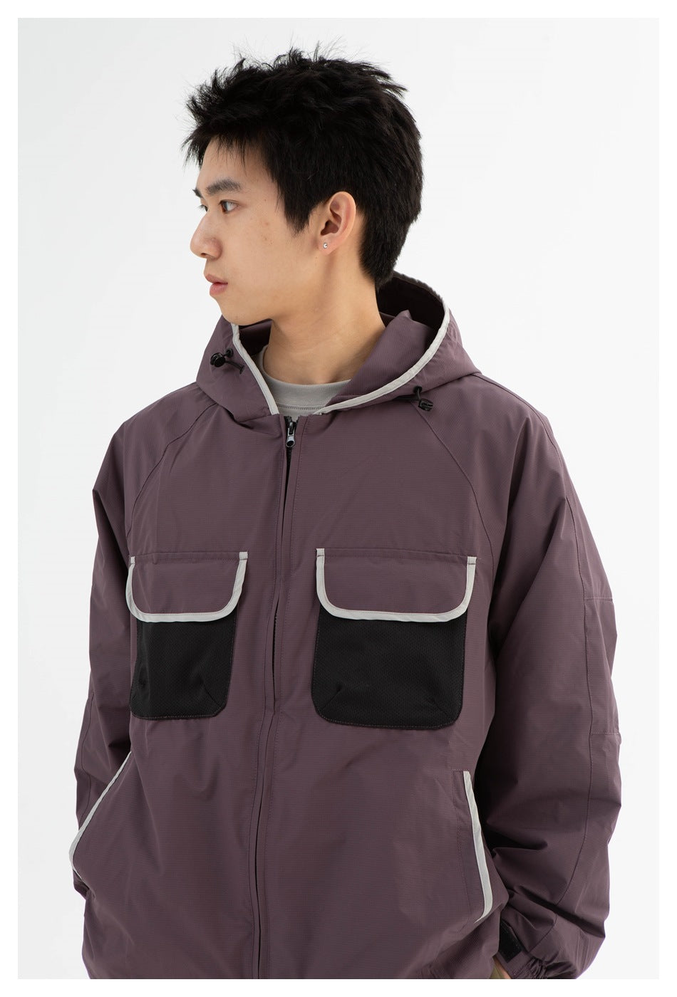 Man wearing a mauve hooded jacket with white-trimmed black chest pockets, shown from the front.