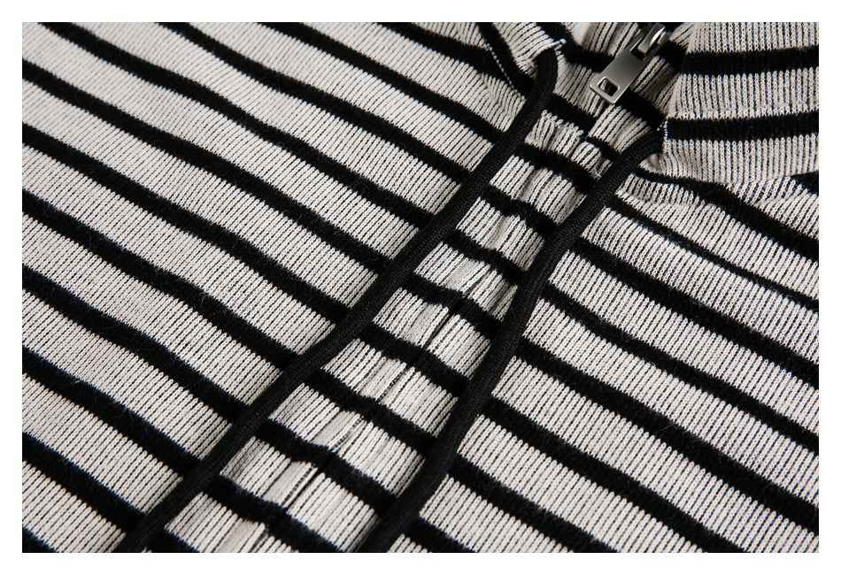 Close-up of the black zipper and cream-and-black horizontal stripes on the garment front.