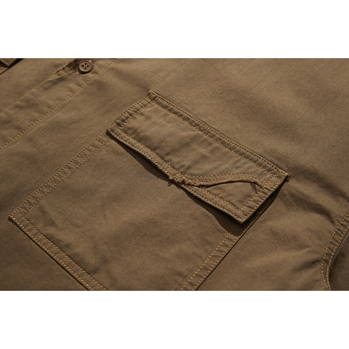 Close-up of a brown shirt's large flap pocket with double stitching and a button above it.