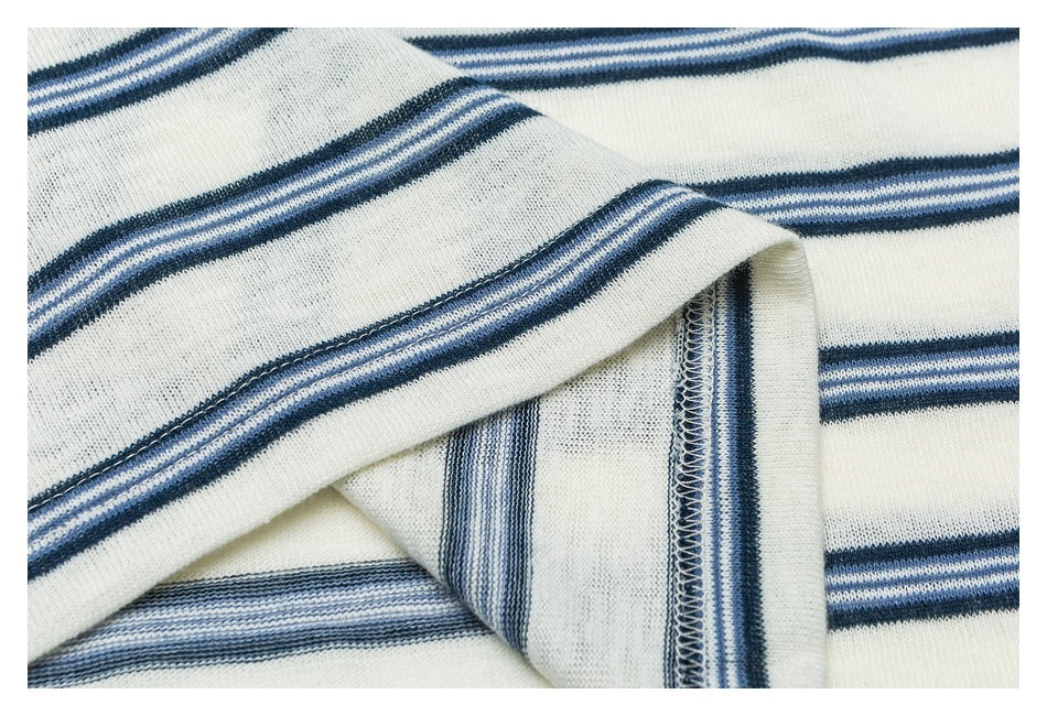 Close-up of folded striped fabric showing the garment's inner overlocked seam.