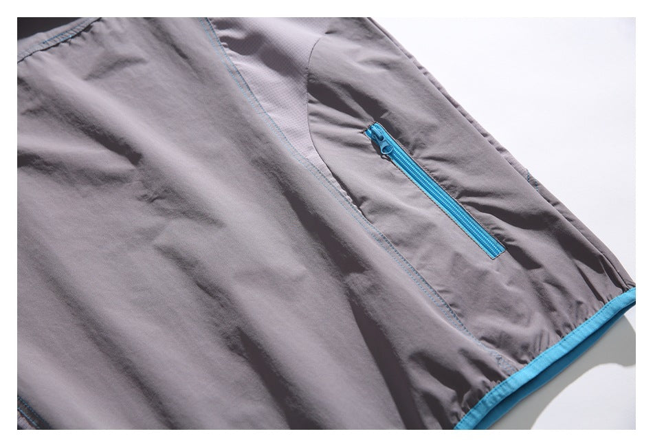 Gray garment panel with a bright blue zippered pocket, blue stitching, and blue hem trim.
