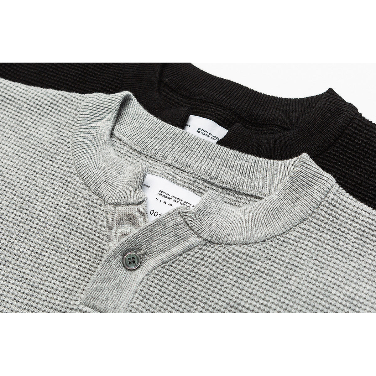 Close-up of gray and black knit Henley tops, showing ribbed collars and a button placket.