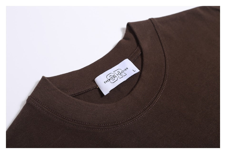 Close-up of a dark brown crew-neck shirt collar with a white neck label.