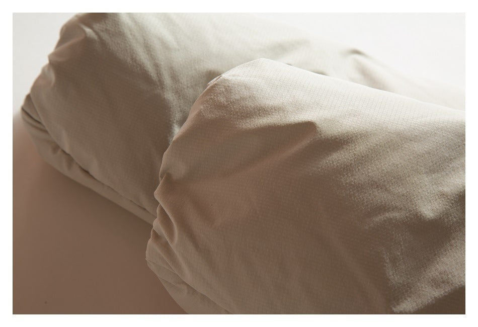 Close-up of a folded, stitched section of cream garment fabric.