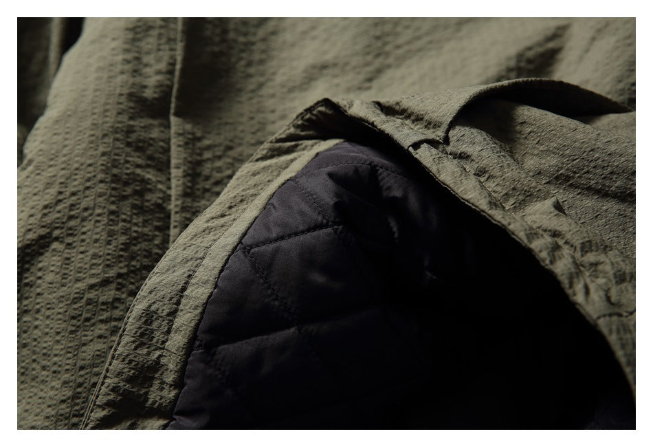 Close-up of the olive jacket opened to reveal dark quilted lining.