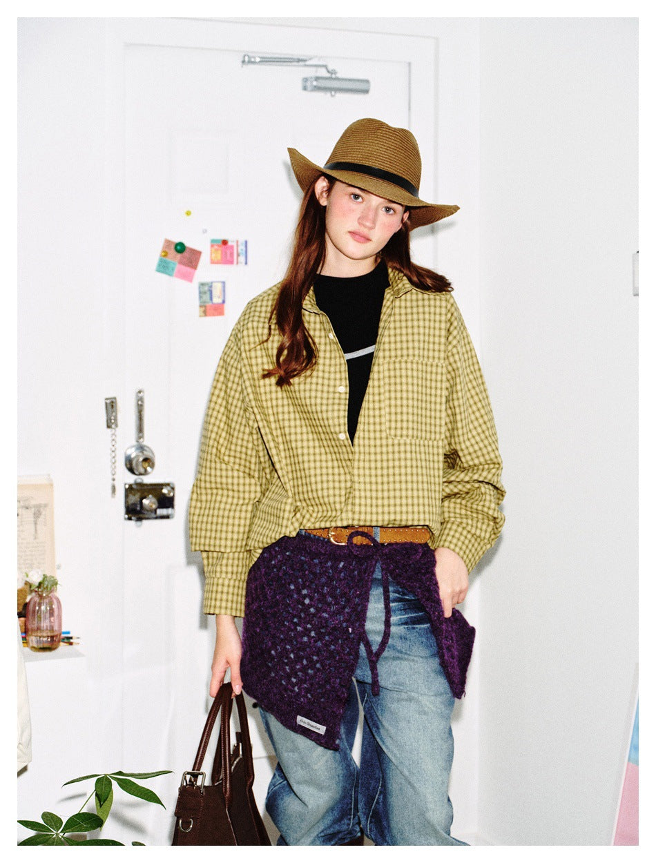 Model wearing a yellow checked button-up shirt, shown with a purple knit wrap and blue jeans.