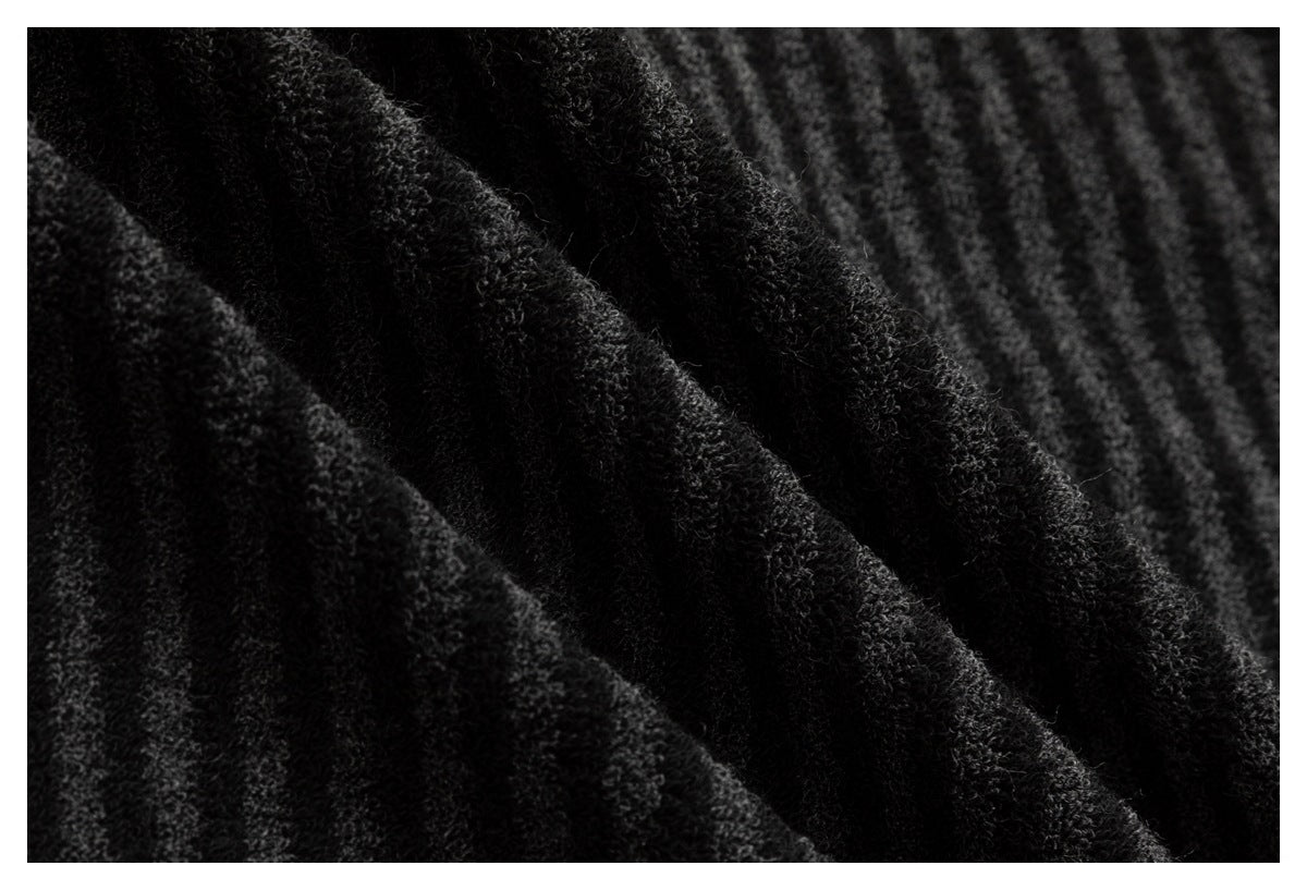 Extreme close-up of fuzzy black and charcoal fabric with a subtle striped pattern.