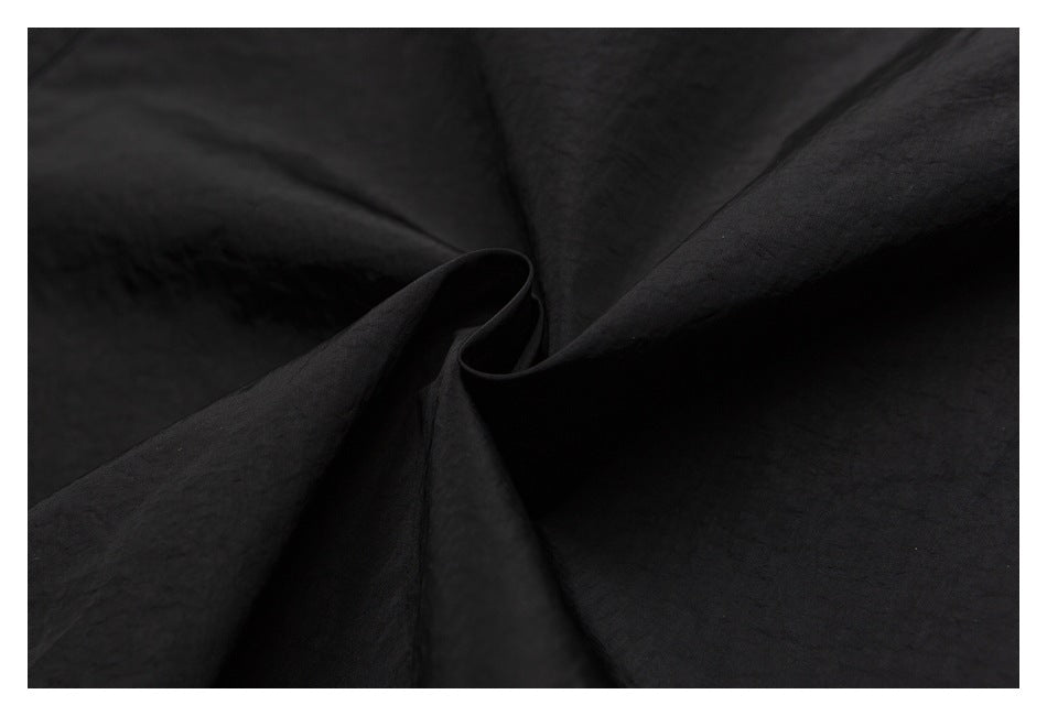 Close-up of black fabric draped into soft folds.