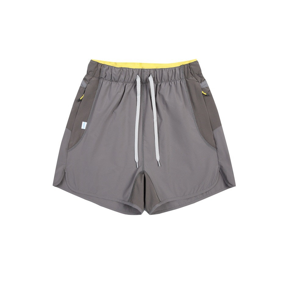 Gray drawstring shorts with darker gray side panels and yellow waistband lining, flat lay front view