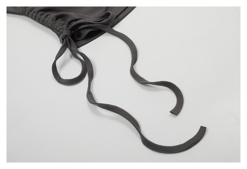 Close-up of a gathered dark charcoal waistband with long matching drawstrings.