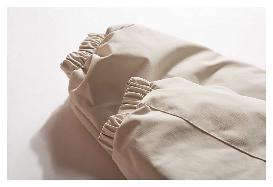 Close-up of gathered elastic edges on a beige garment.