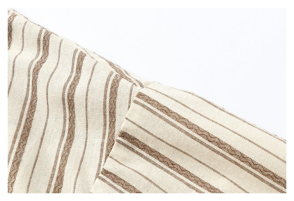 Close-up of cream fabric with brown stripe patterns and a curved stitched seam.