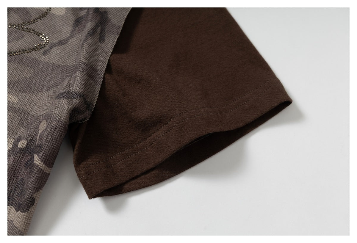 Close-up of a brown short sleeve and stitched hem beside gray-brown camouflage fabric.