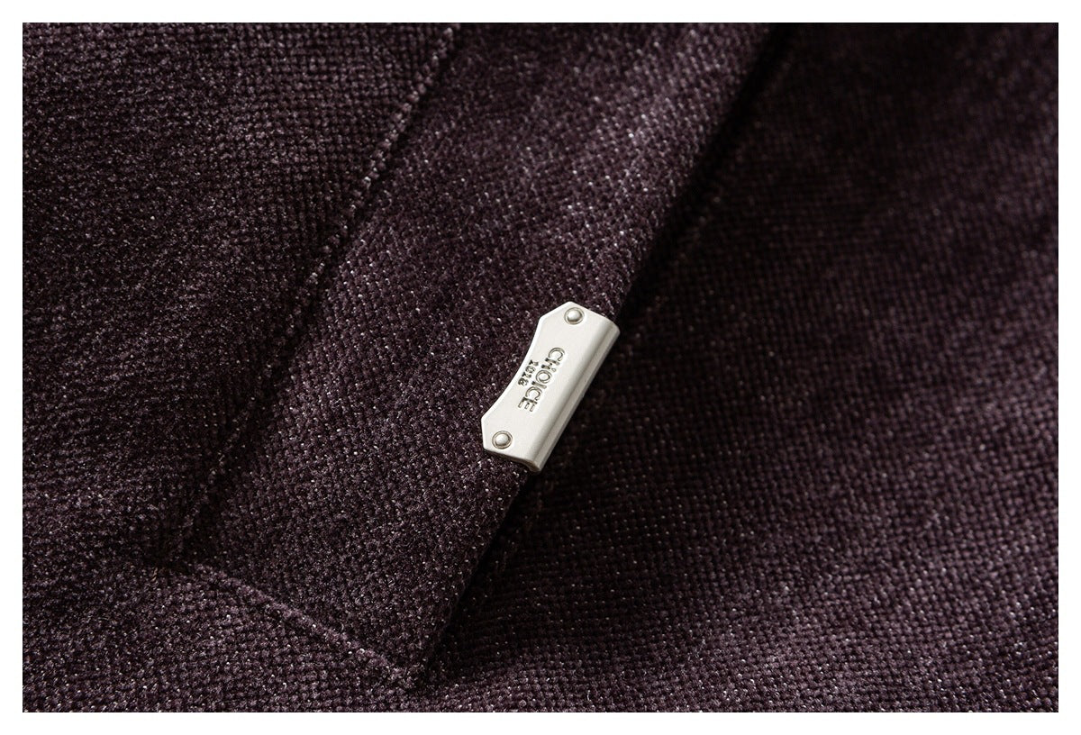 Close-up of a small silver metal tab attached to plum textured fabric.