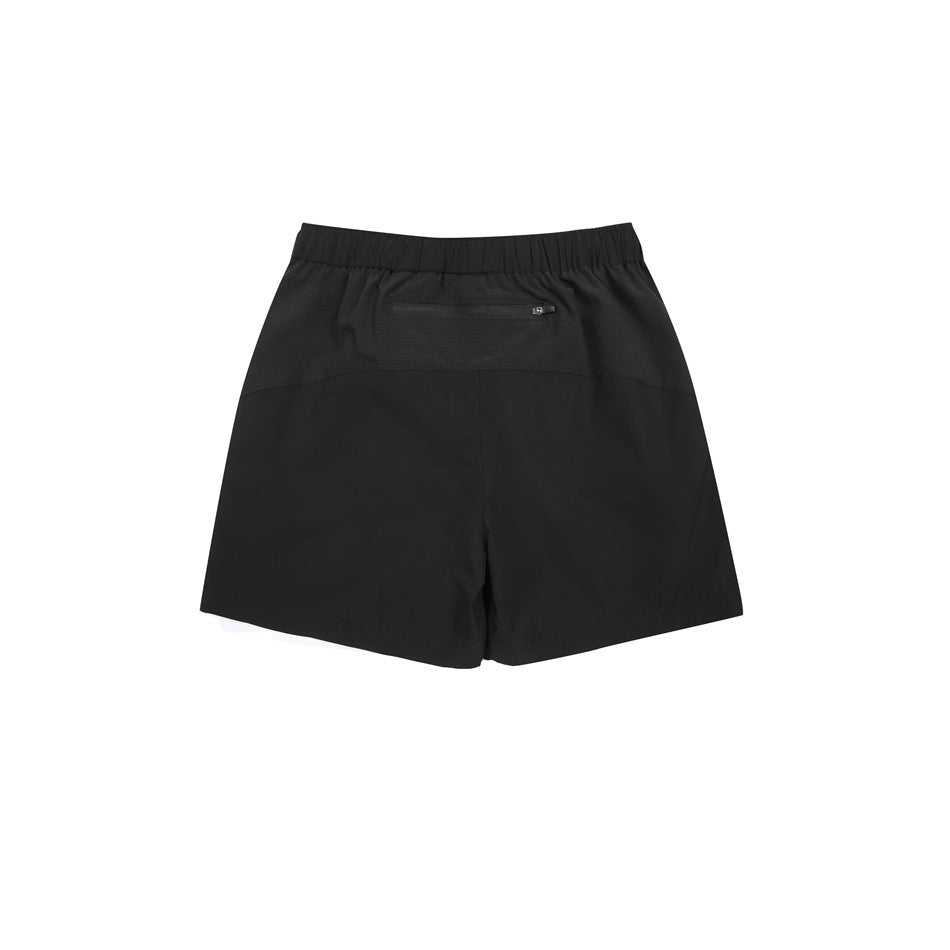 Back view of black athletic shorts with an elastic waistband and a small zip pocket.
