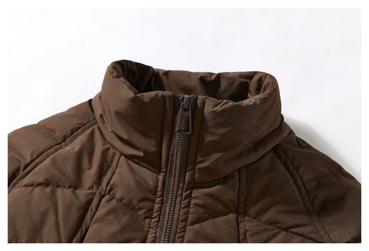 Close-up of a brown quilted jacket's high collar and front zipper.