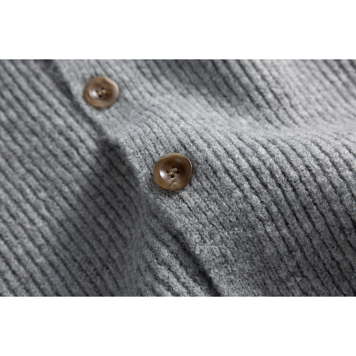 Close-up of gray ribbed knit fabric with two brown buttons.