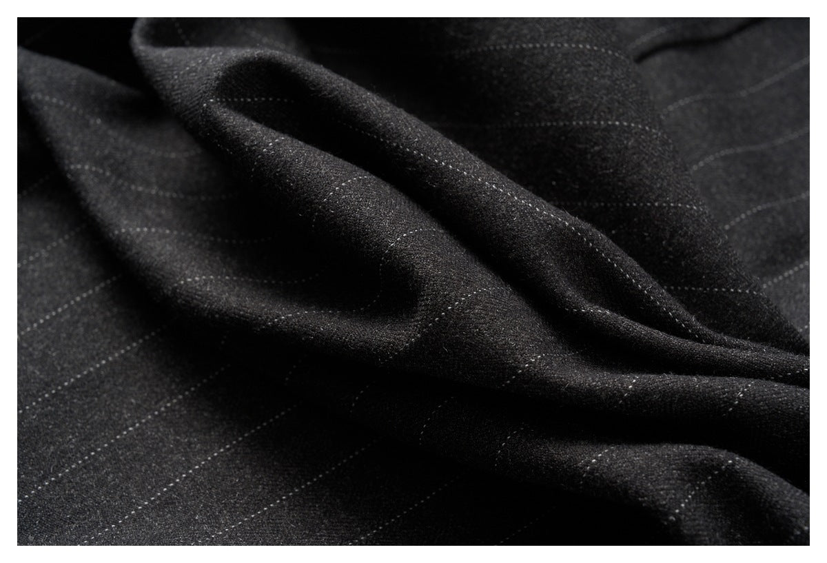 Draped black fabric showing a fine pinstripe pattern and soft folds.