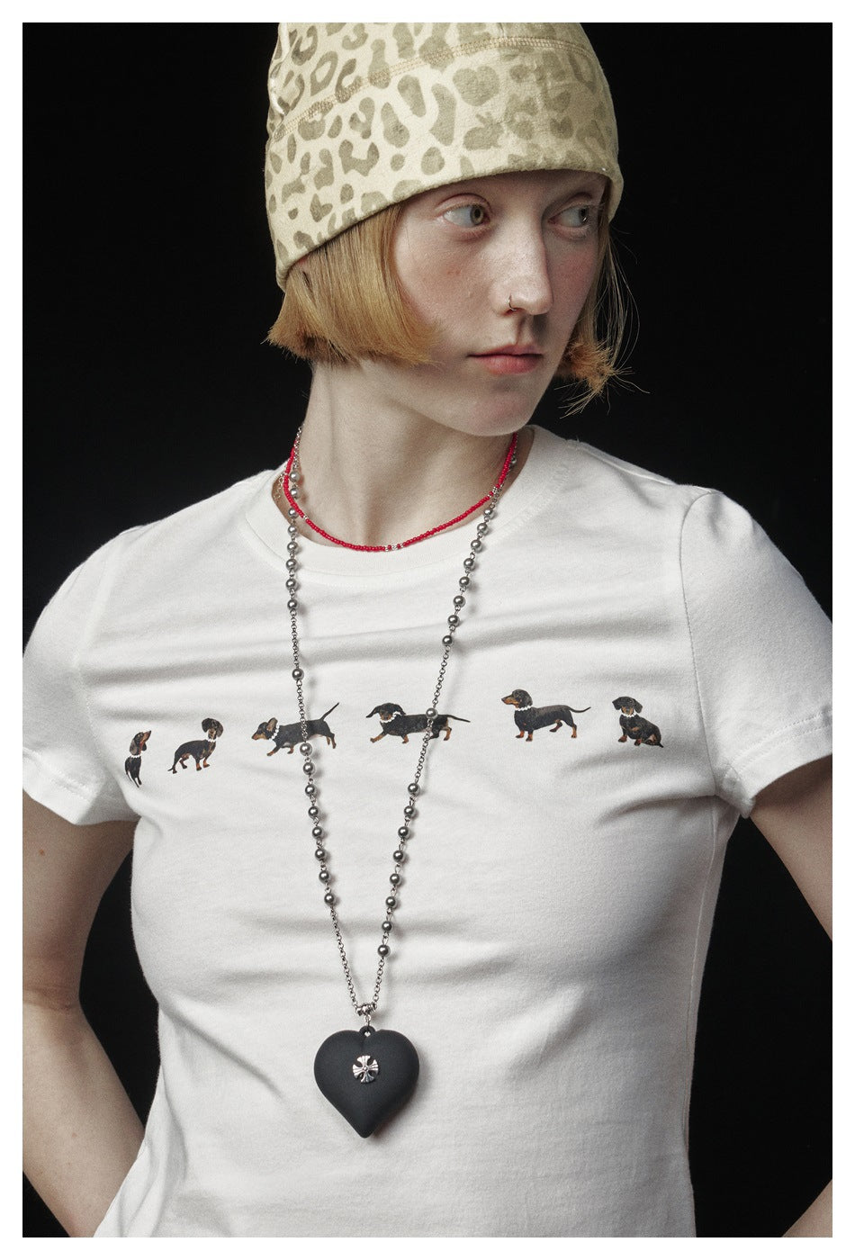 Close-up of the dachshund illustration row on a white T-shirt worn by a model.
