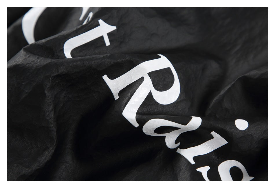 Angled close-up of white lettering printed across the crinkled black jacket.