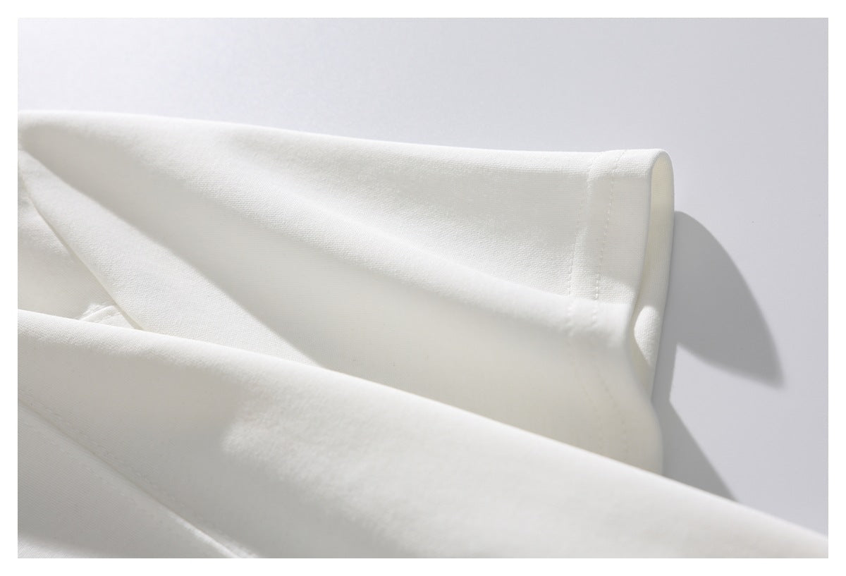 Close-up of a white garment's folded edge and neat stitching.