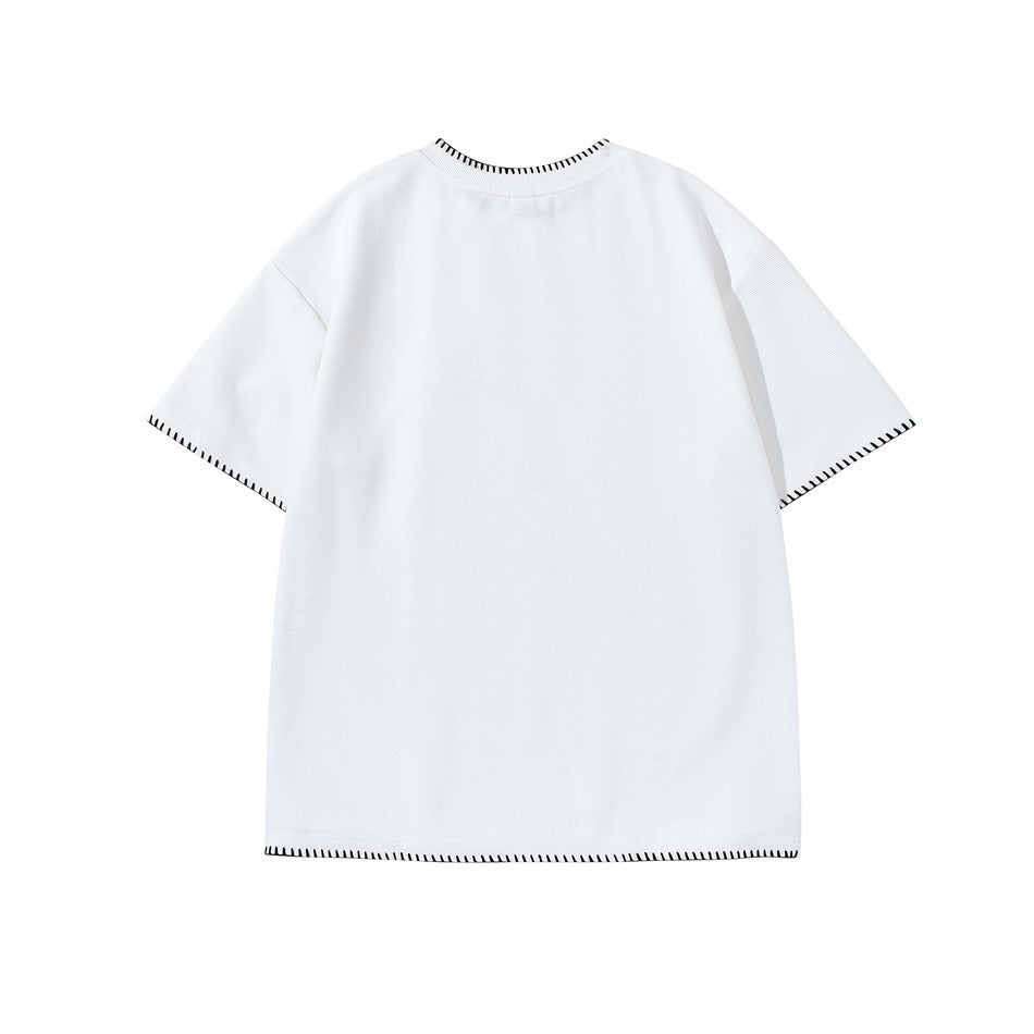 Back view of a white short-sleeve shirt with black contrast stitching at the collar, cuffs, and hem.