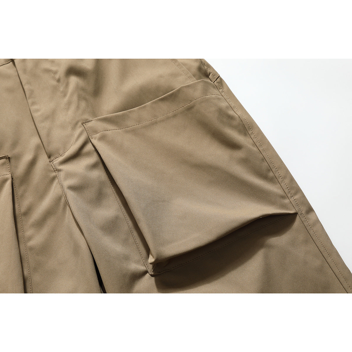 Close-up of a large flap cargo pocket on tan pants, showing its stitching and construction.