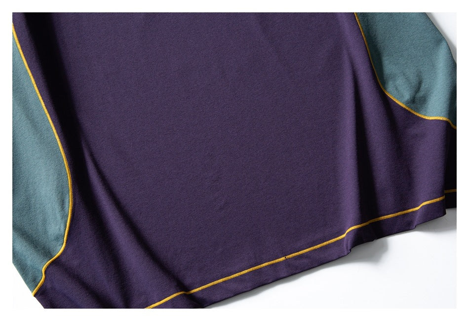 Close-up of the purple garment's hem and teal side panels, outlined with mustard-yellow stitching.