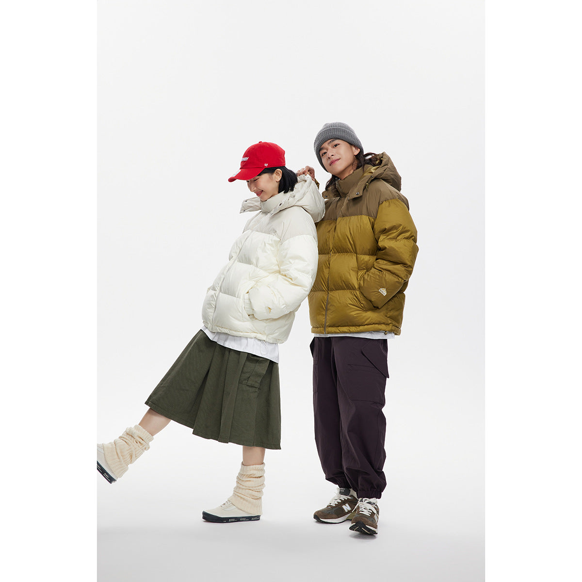 Two models wear puffer jackets: one white and one olive-and-mustard color-blocked, styled with winter casualwear.