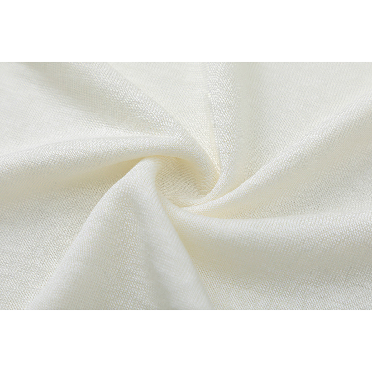Macro view of softly folded ivory T-shirt fabric and its knit texture.