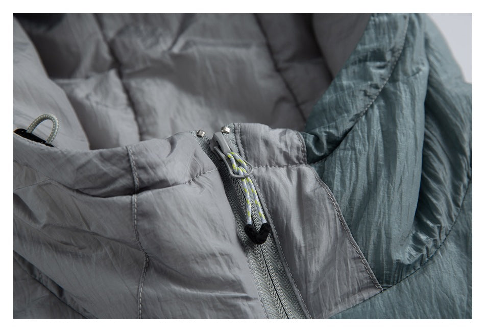 Close-up of the jacket's front zipper and corded pull, with gray and teal padded panels.