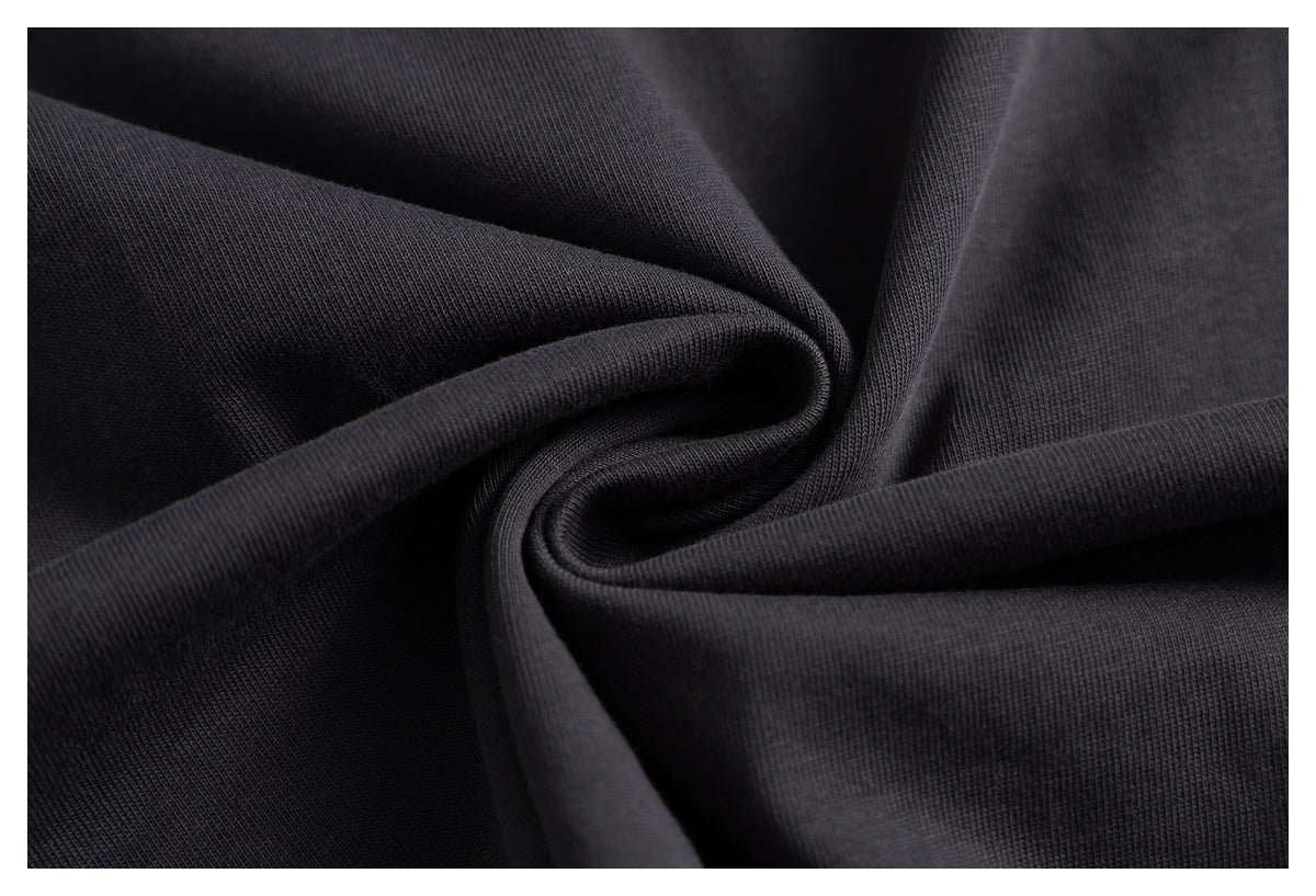 Close-up of black knit fabric draped in soft folds, showing its ribbed texture.