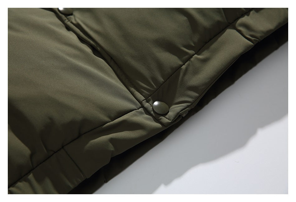Close-up of a snap button and overlapping front placket near the lower edge of the olive jacket.