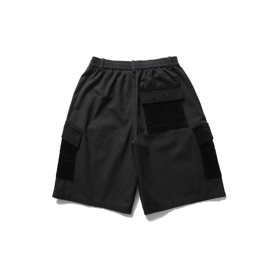 Back view of black cargo shorts with elastic waistband, corduroy-patched back pocket and side cargo pockets