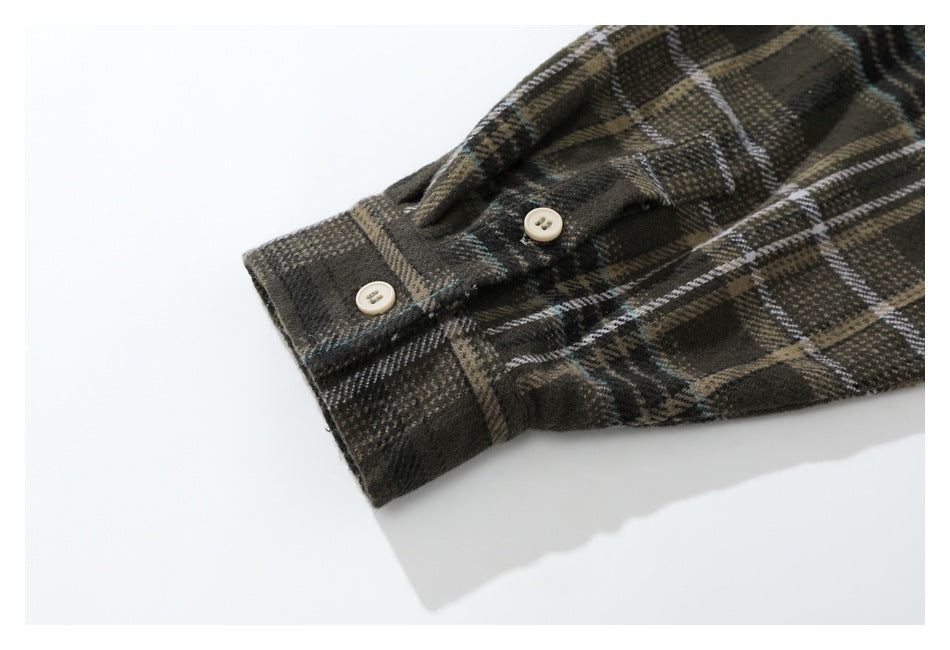 Close-up of a plaid shirt cuff with two cream buttons.