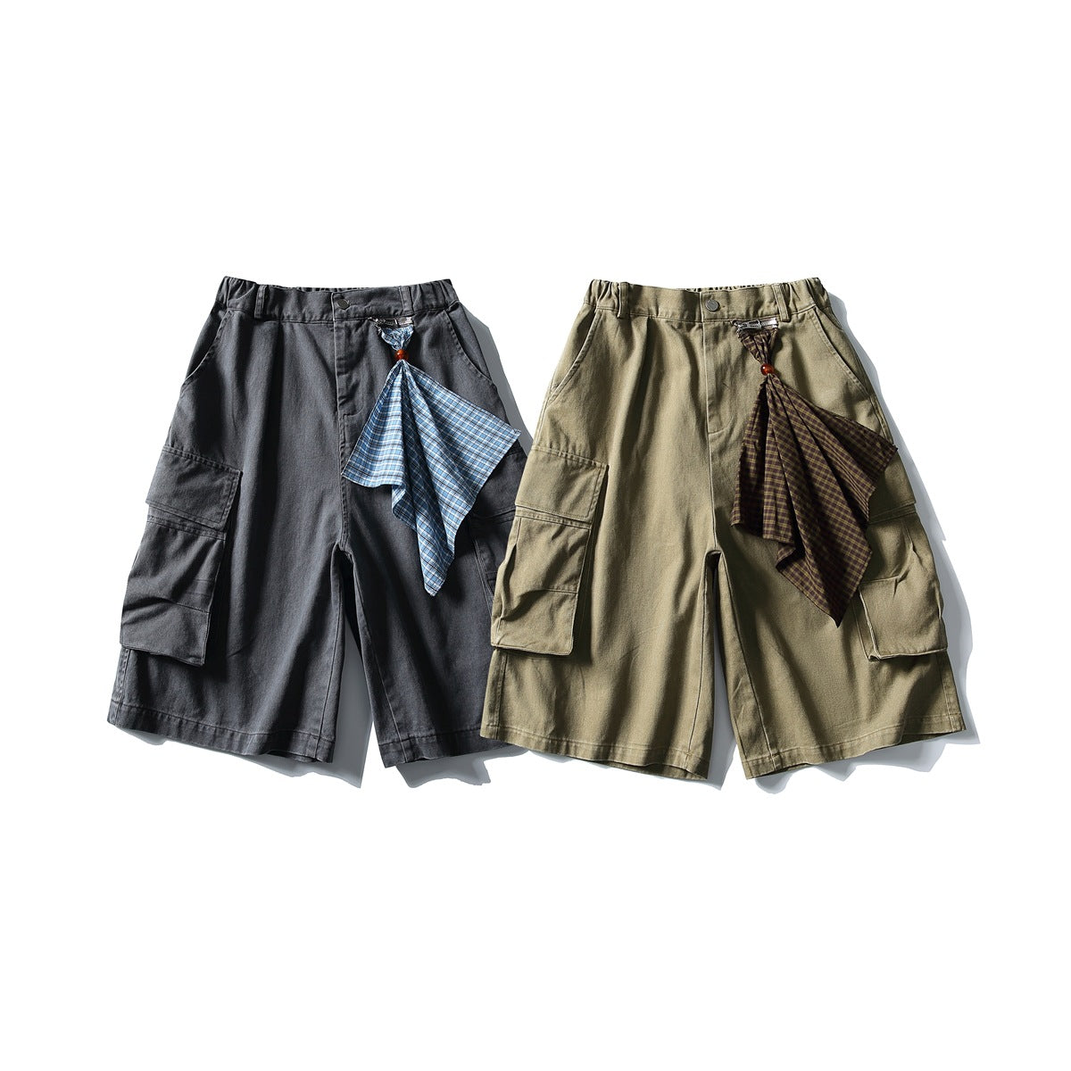 Front view of charcoal and khaki cargo shorts, each with large side pockets and a plaid fabric accent.