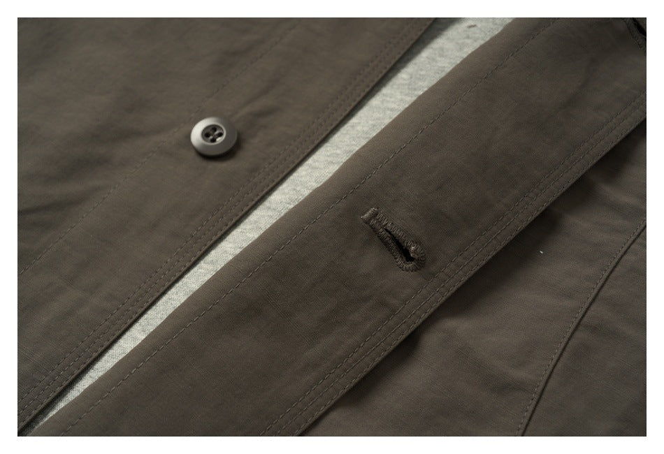 Close-up showing a button and stitched buttonhole on the dark olive-brown garment's front placket.