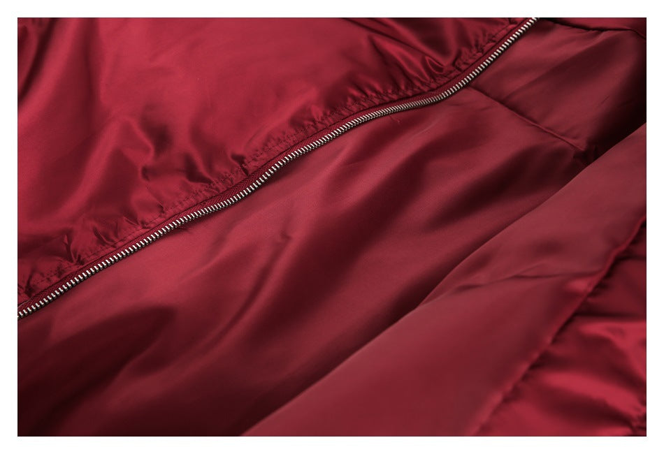 Close-up of a diagonal silver zipper across the burgundy jacket fabric.