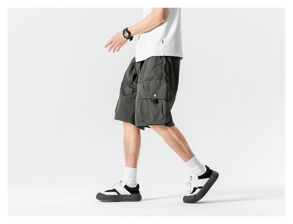 Side view of a model wearing dark charcoal cargo shorts with a large flap pocket.