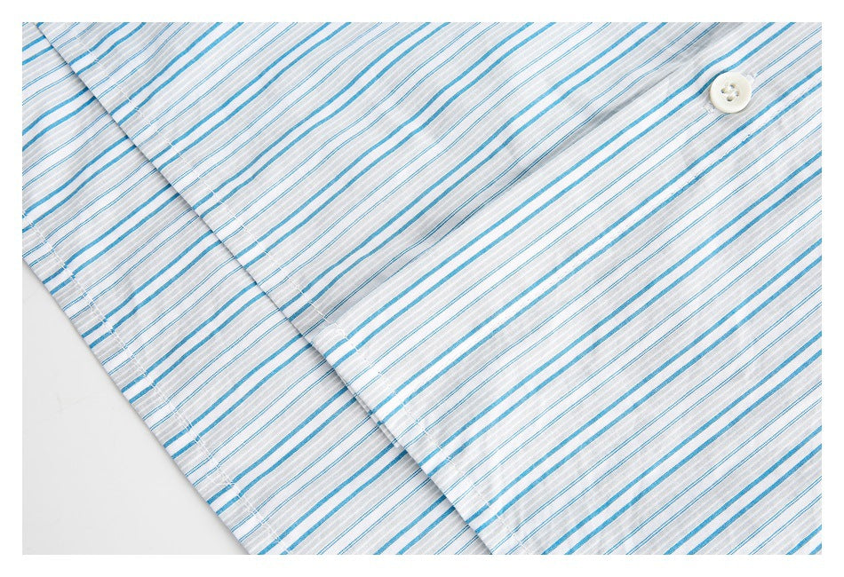 Close-up of a white shirt with blue and gray stripes, showing a button and the button placket.