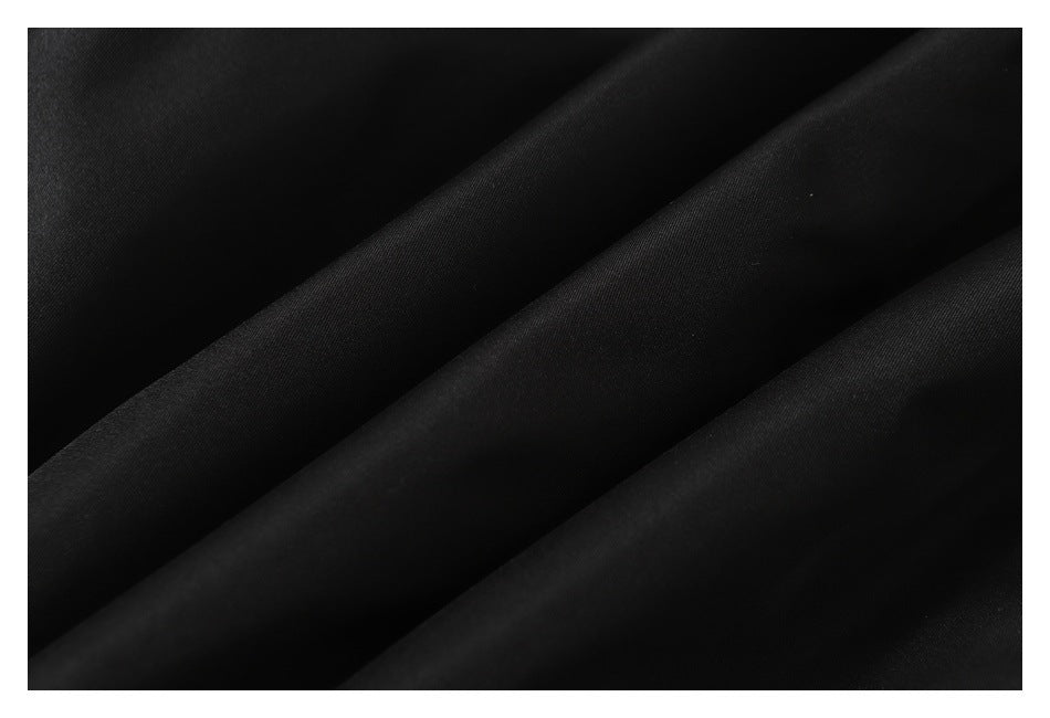 Close-up of smooth black jacket fabric arranged in soft folds.